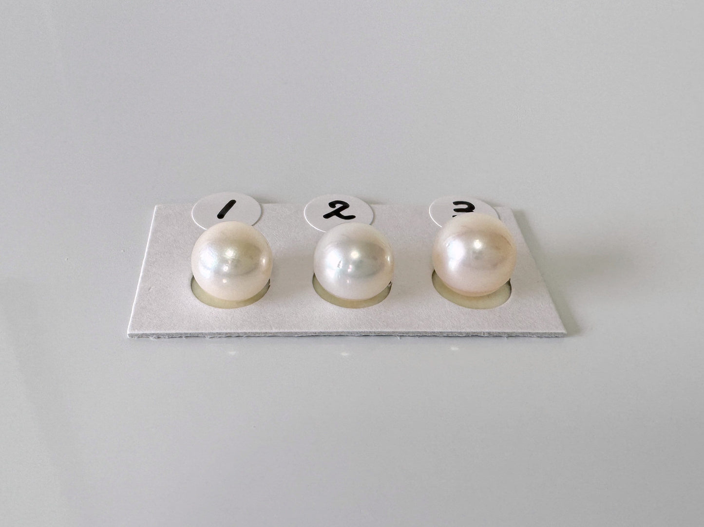 three pearls sitting on top of a piece of paper