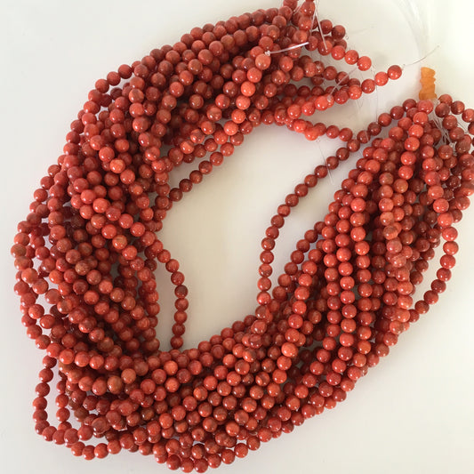 a string of red beads on a white surface