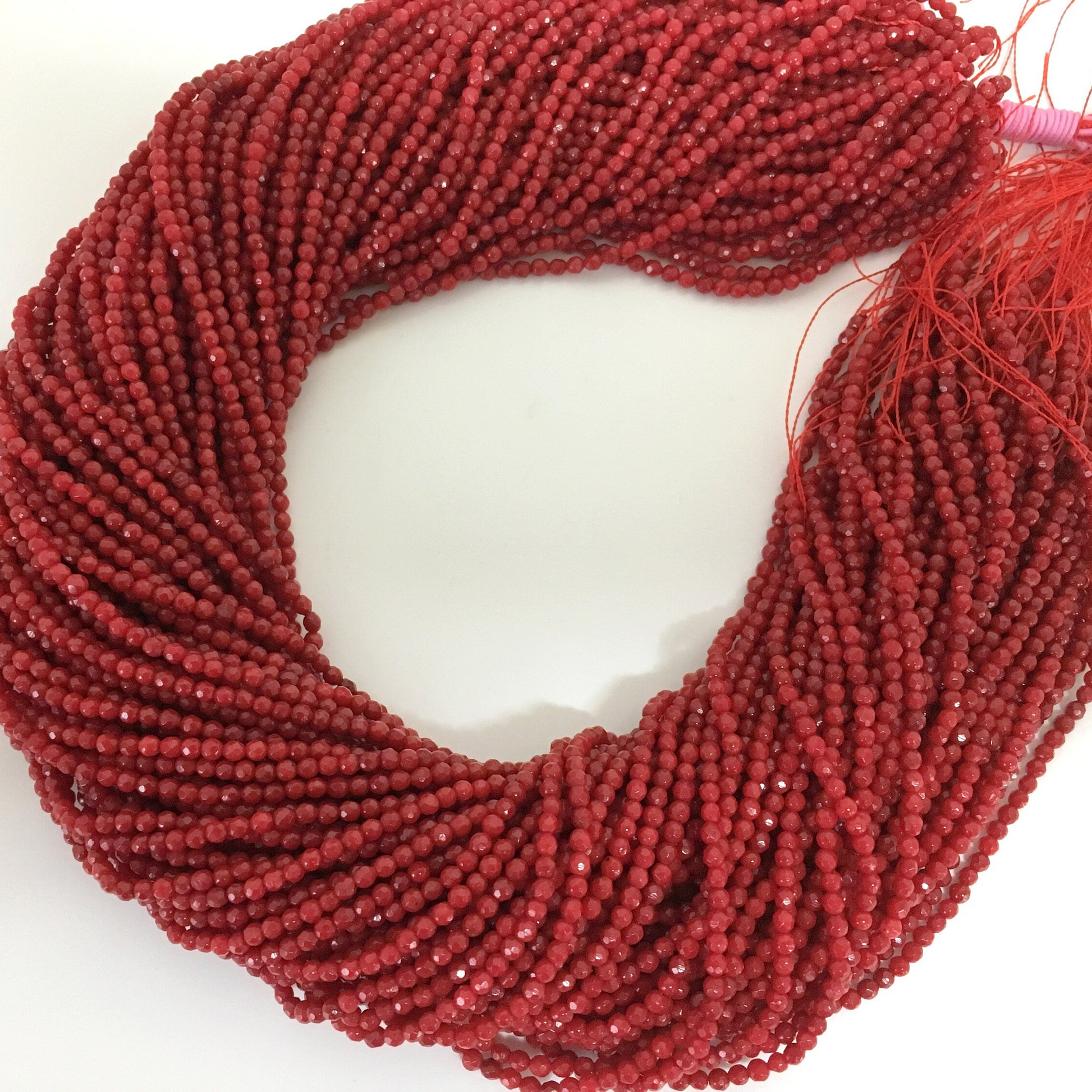 a close up of a beaded necklace on a white surface