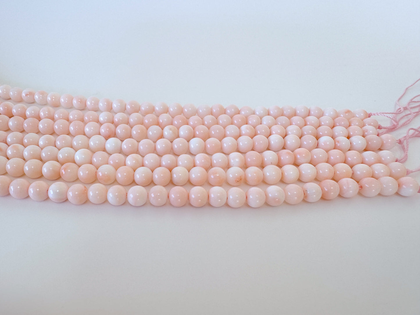 A row of pink coral beads on a white background.