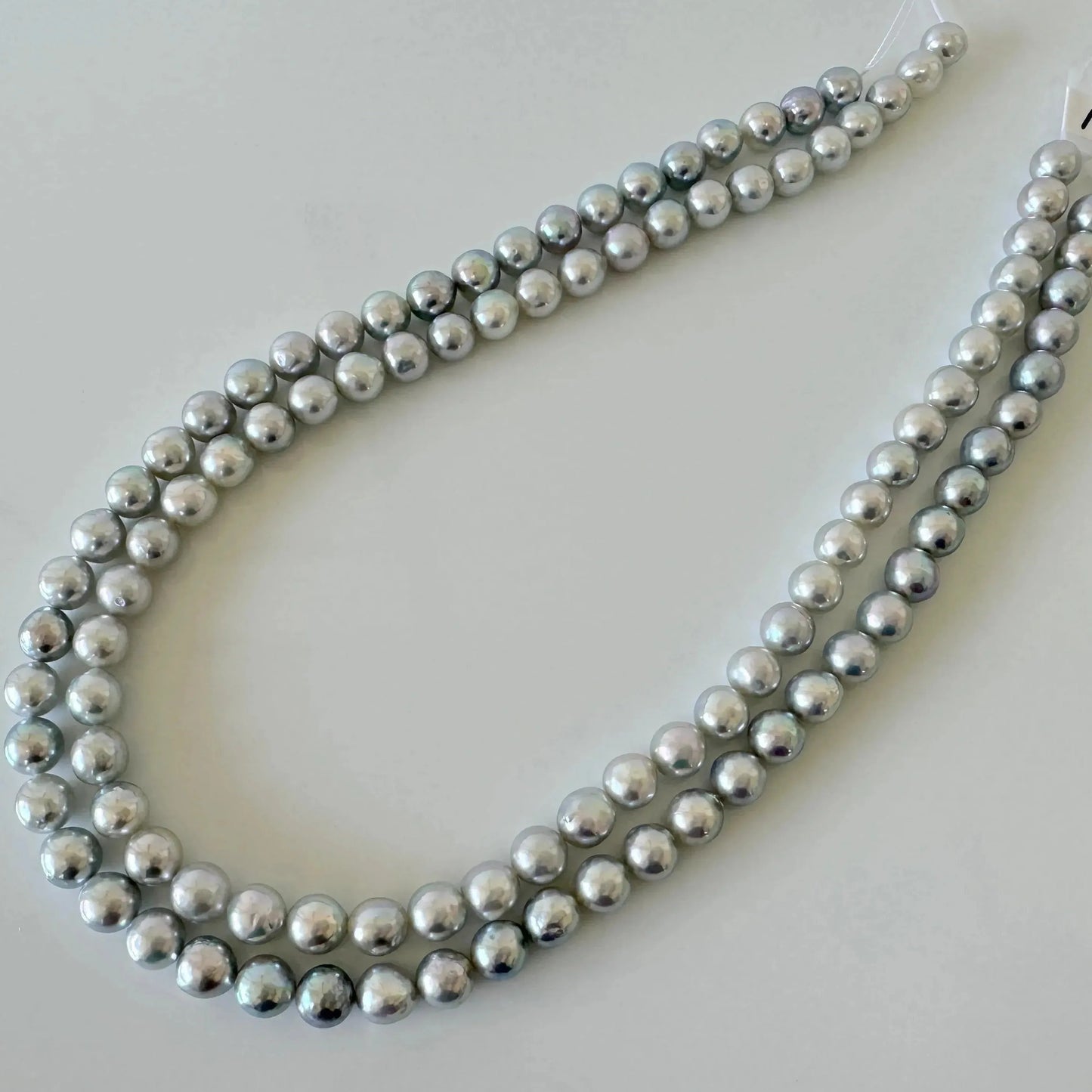 A necklace composed of numerous silver-colored pearls arranged in a decorative pattern.