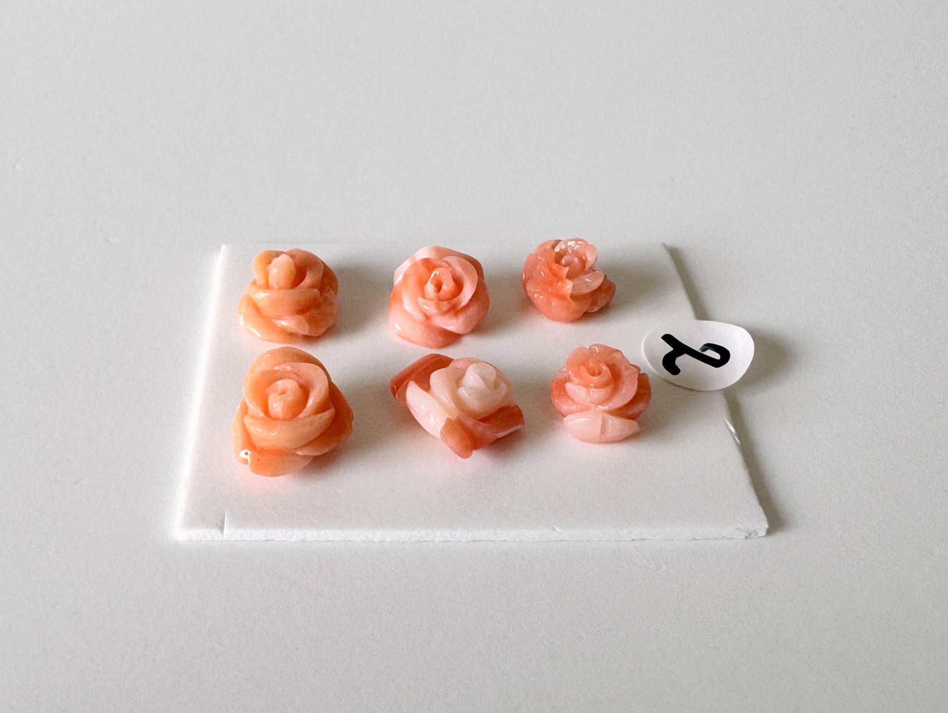A white surface with six pink rose-shaped objects arranged in two rows of three.