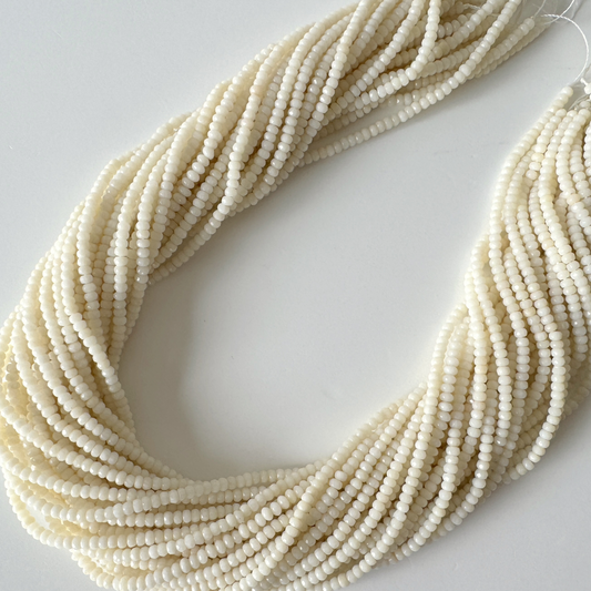 A large collection of white beads arranged in a spiral pattern, creating a visually striking and intricate design.