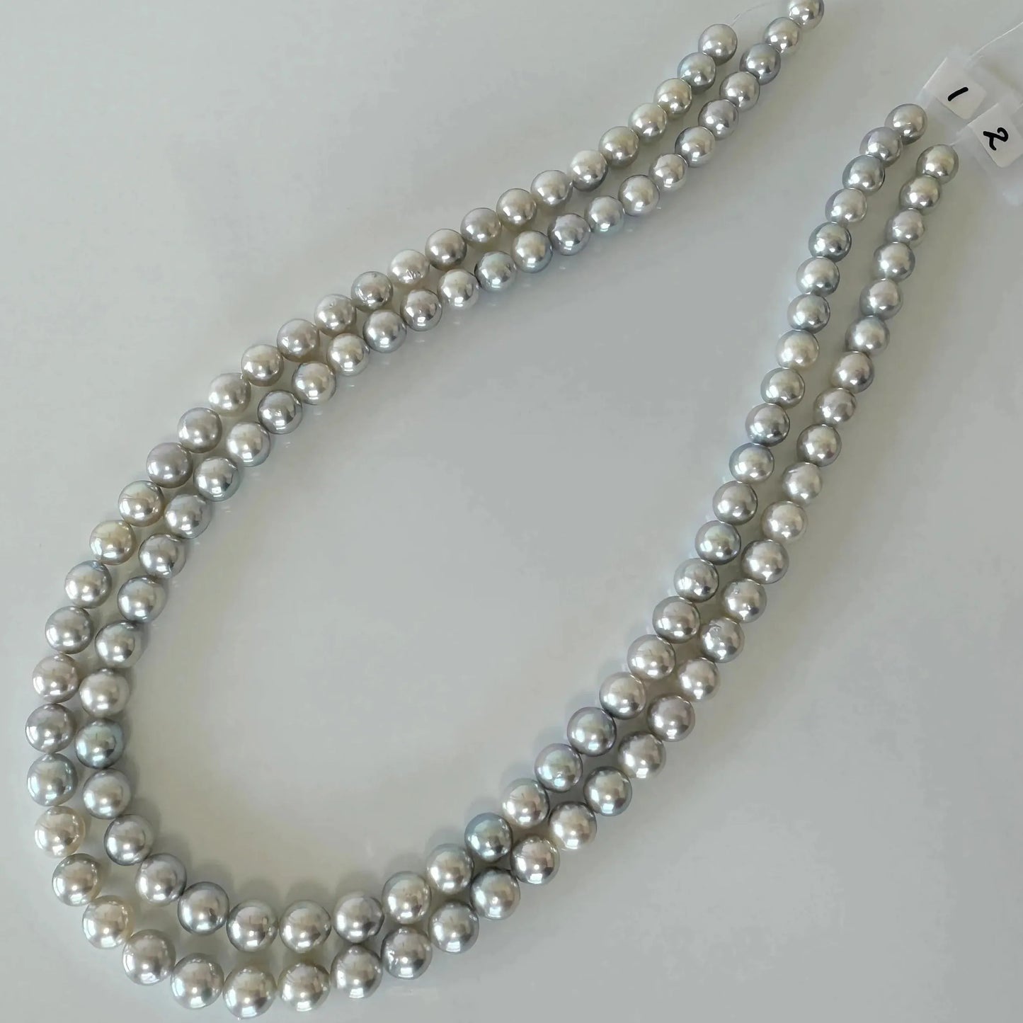A necklace made of numerous silver-colored pearls arranged in a decorative pattern.