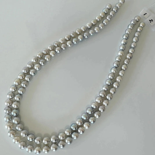 A necklace made of numerous silver-colored pearls arranged in a decorative pattern.