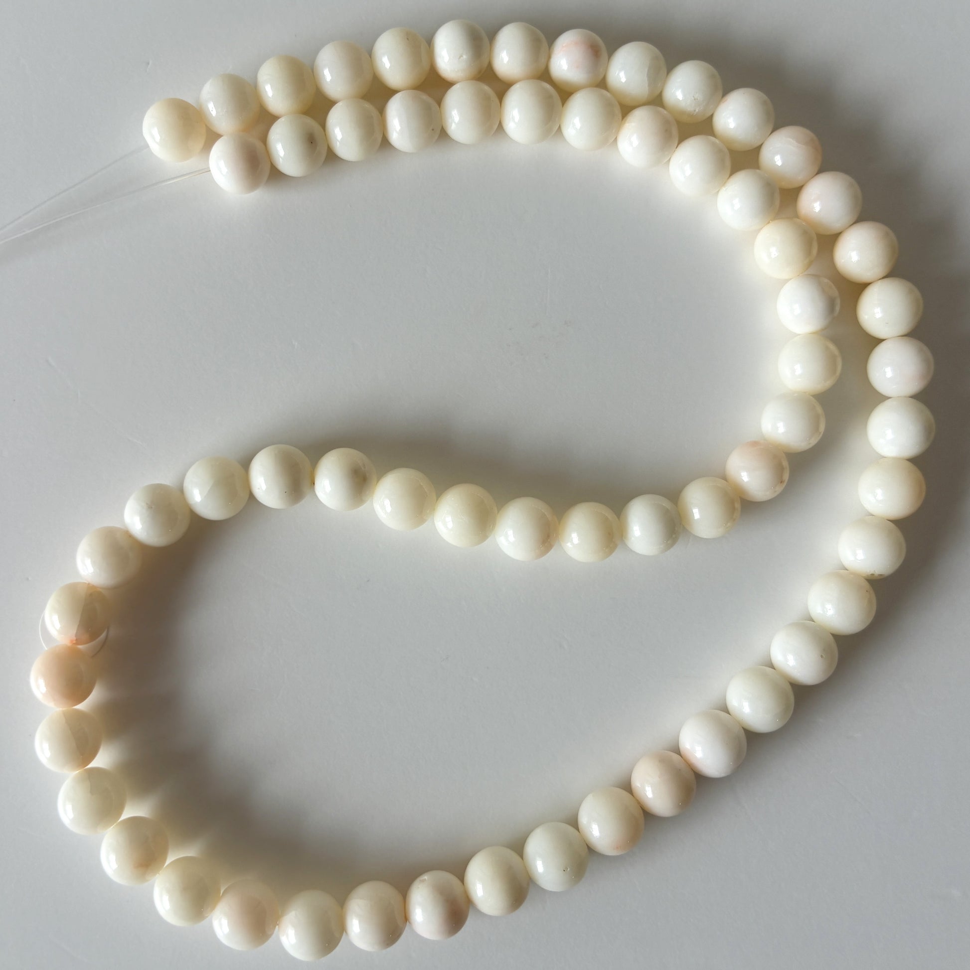A necklace made of white pearls arranged in a curved pattern.
