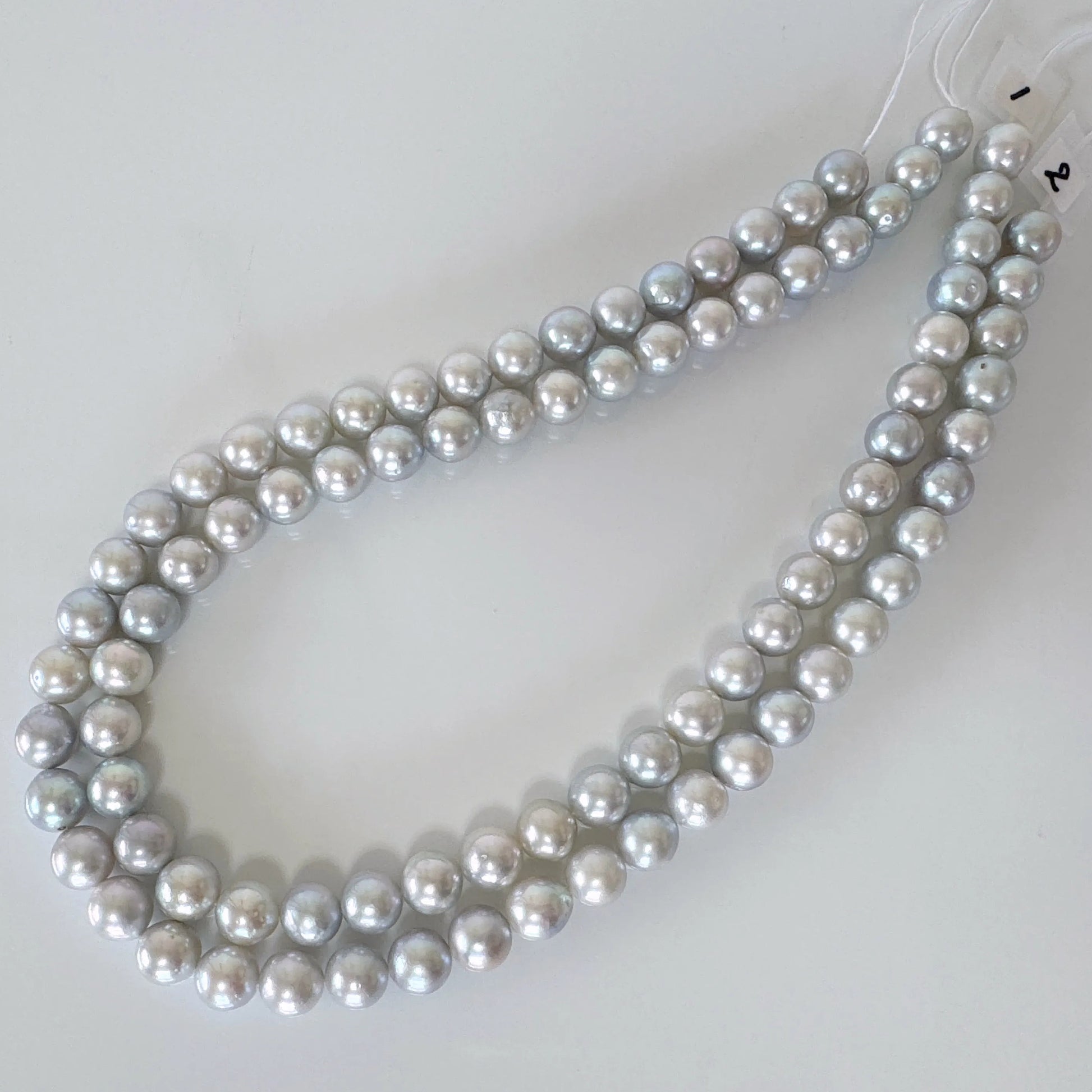 A necklace composed of numerous silver-colored pearls arranged in a circular pattern.