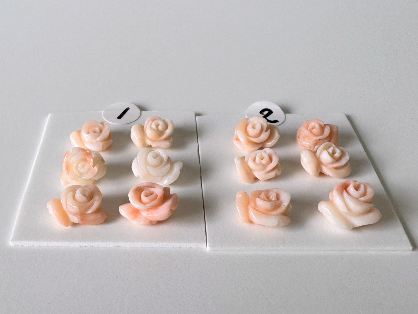 a collection of pink and white rose-shaped objects arranged on a white surface.