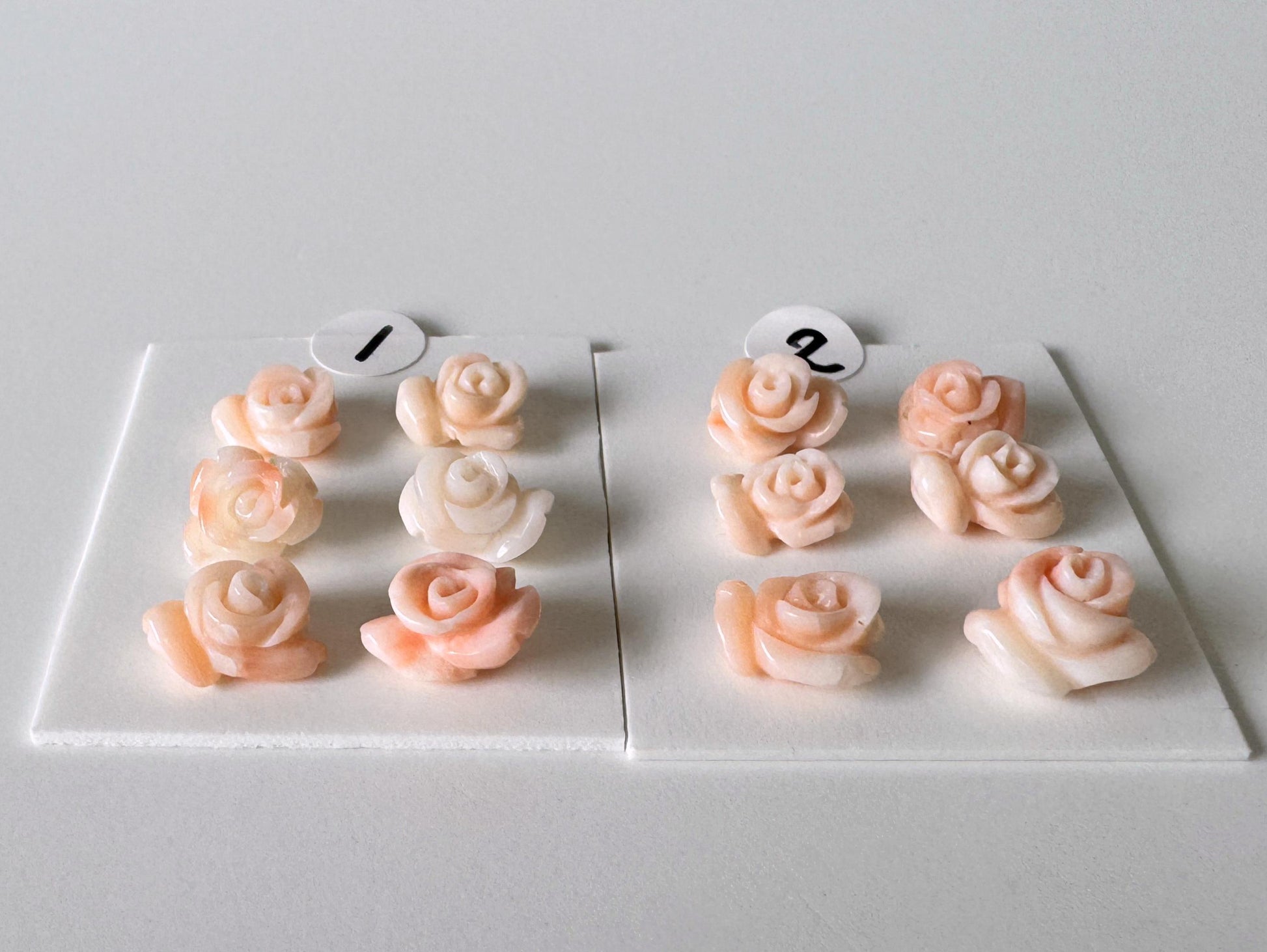 a collection of pink and white rose-shaped objects arranged on a white surface.