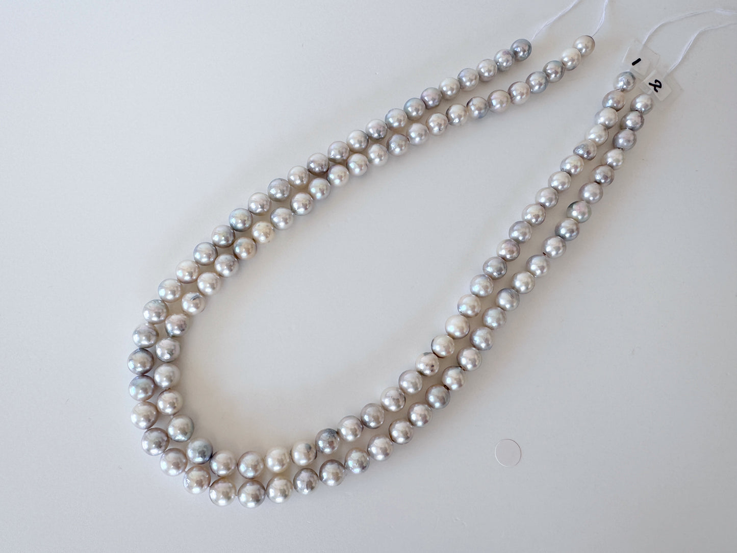 A necklace composed of numerous silver and white pearls arranged in a decorative manner.