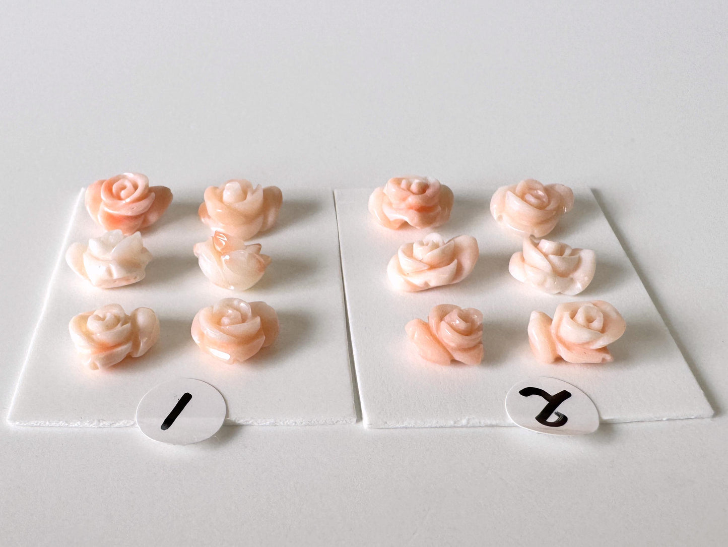 a collection of pink rose-shaped objects, each with a number attached to it. The numbers are 1 and 2, indicating the count of the objects in the image.