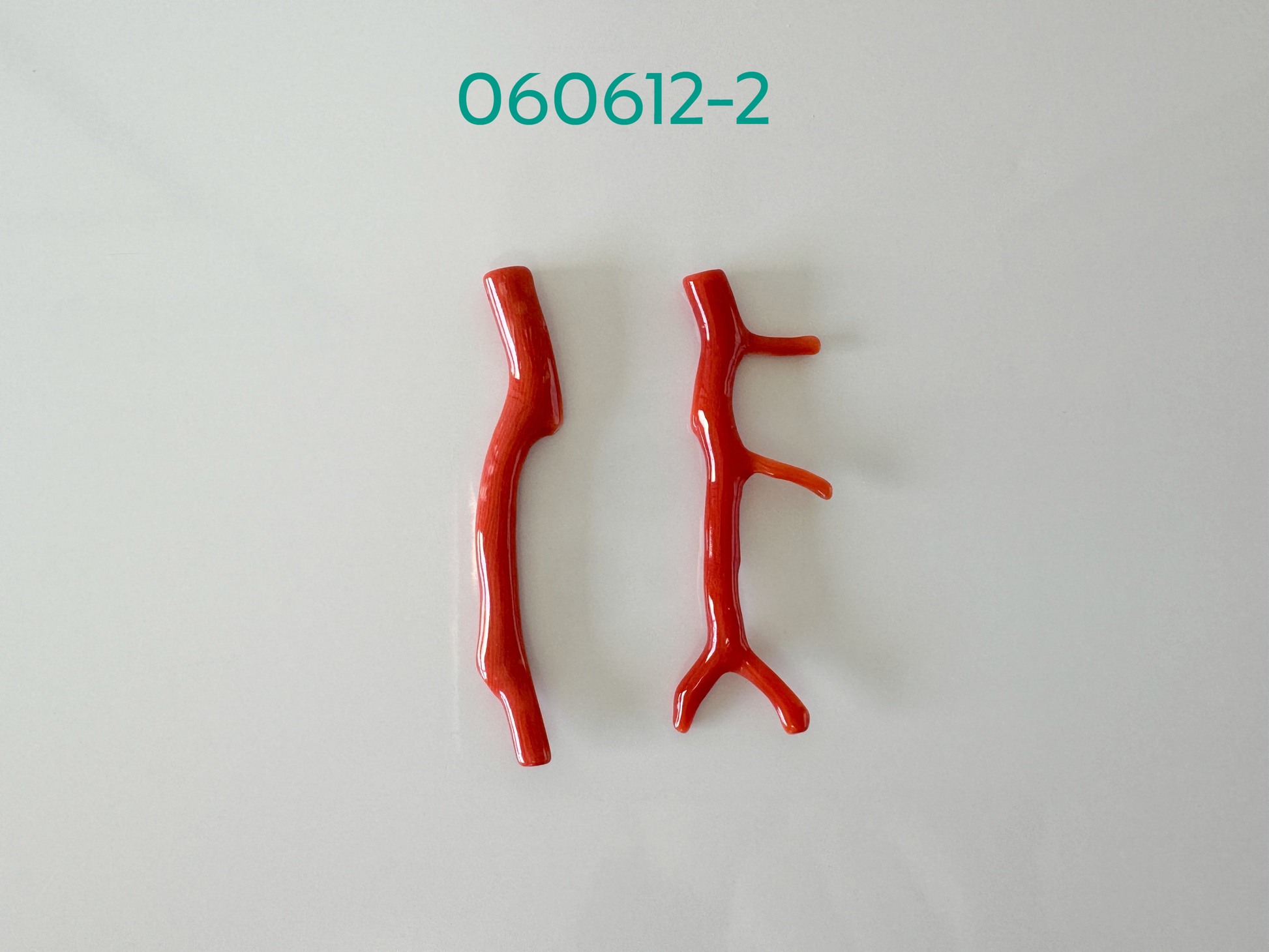 a pair of red plastic branches on a white surface