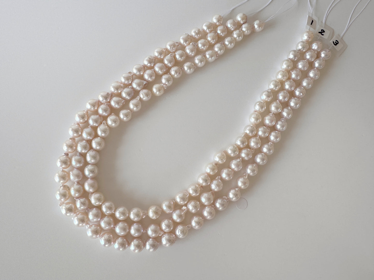 A necklace composed of numerous white pearls arranged in a decorative manner.