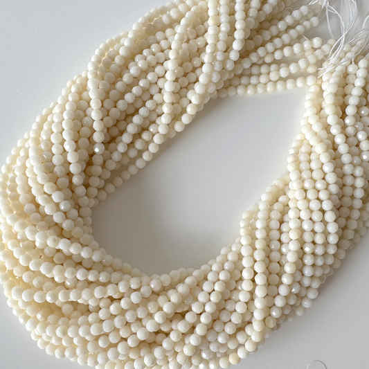 A large collection of white beads arranged in a circular pattern, creating a visually striking and intricate design.