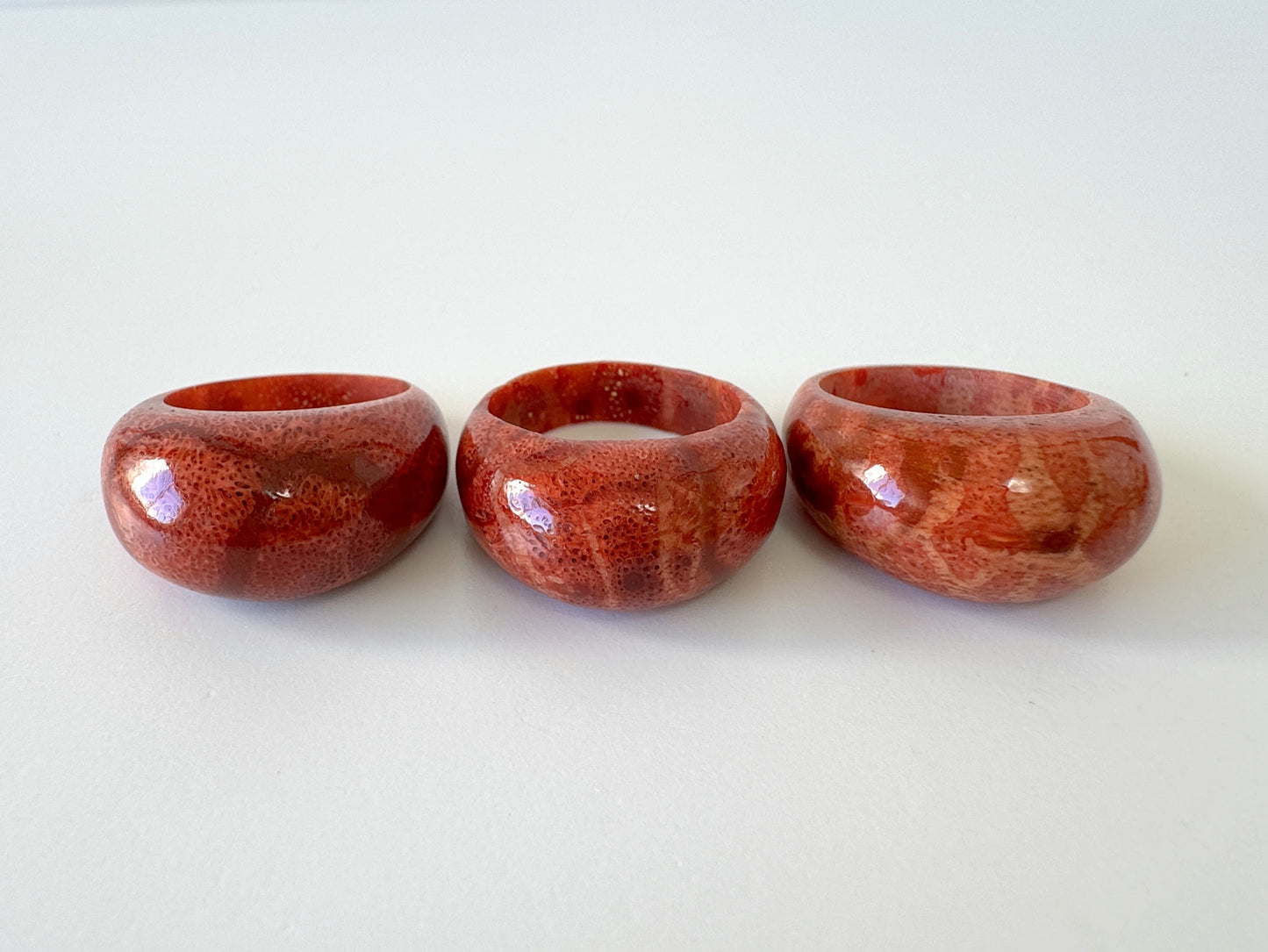 Three red, textured rings are arranged in a row on a white background.