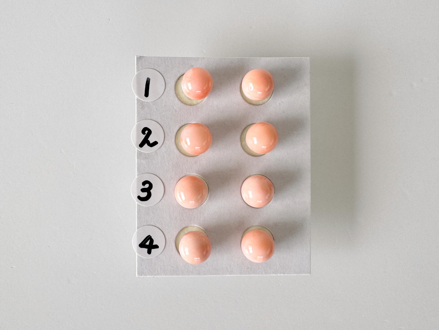 a white board with numbered buttons, each button containing a small orange ball.