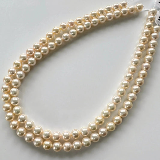 A necklace composed of multiple strands of white pearls is displayed on a white surface.