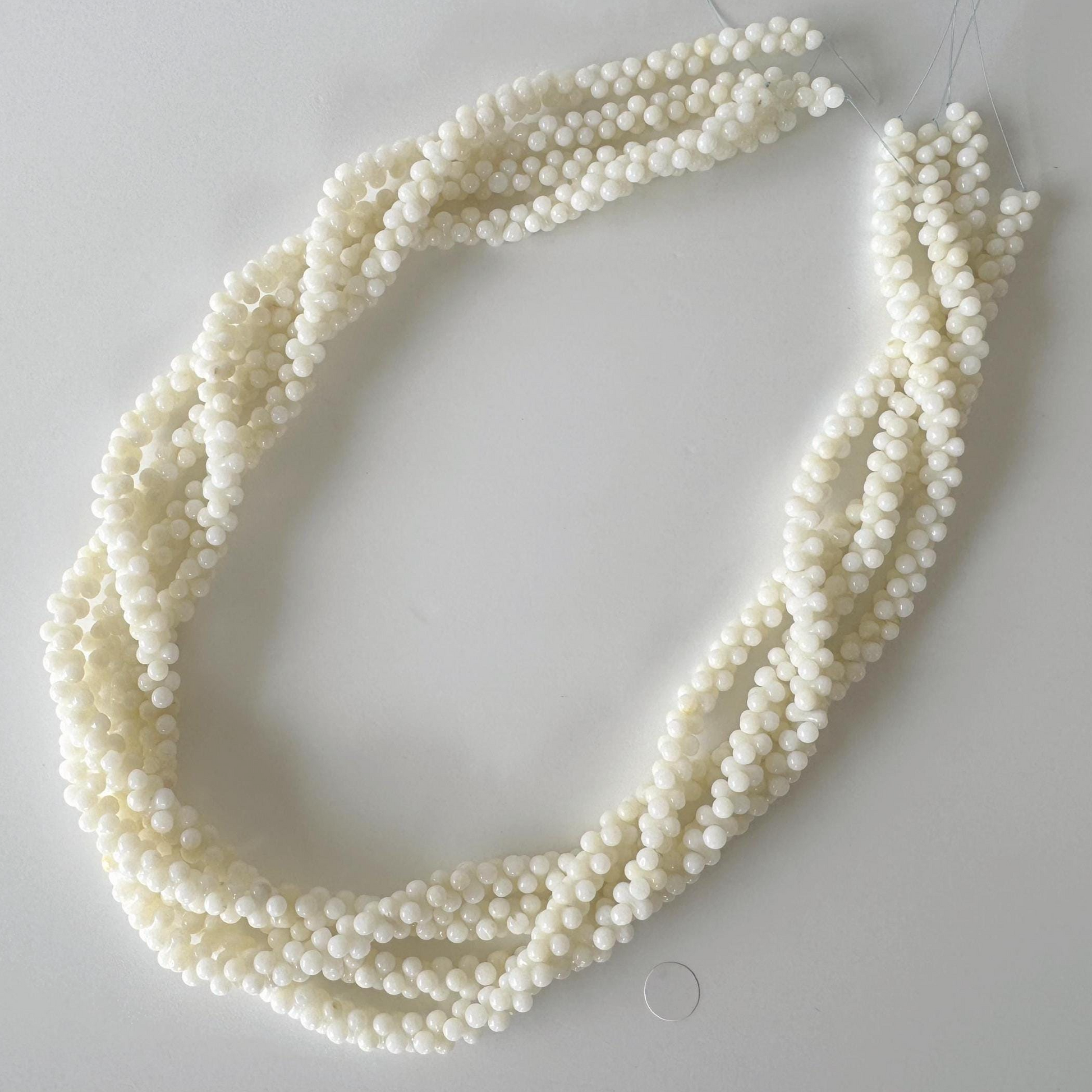A necklace made of small, white beads arranged in a circular pattern.