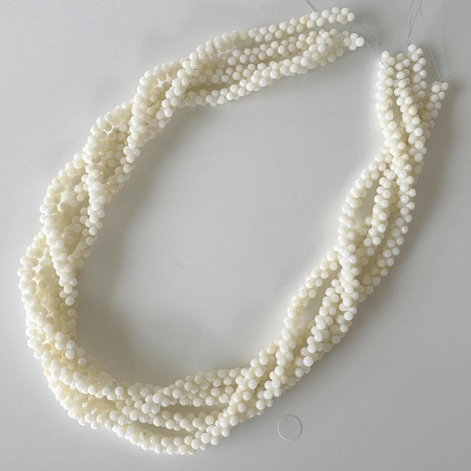 A necklace made of small, white beads arranged in a circular pattern.