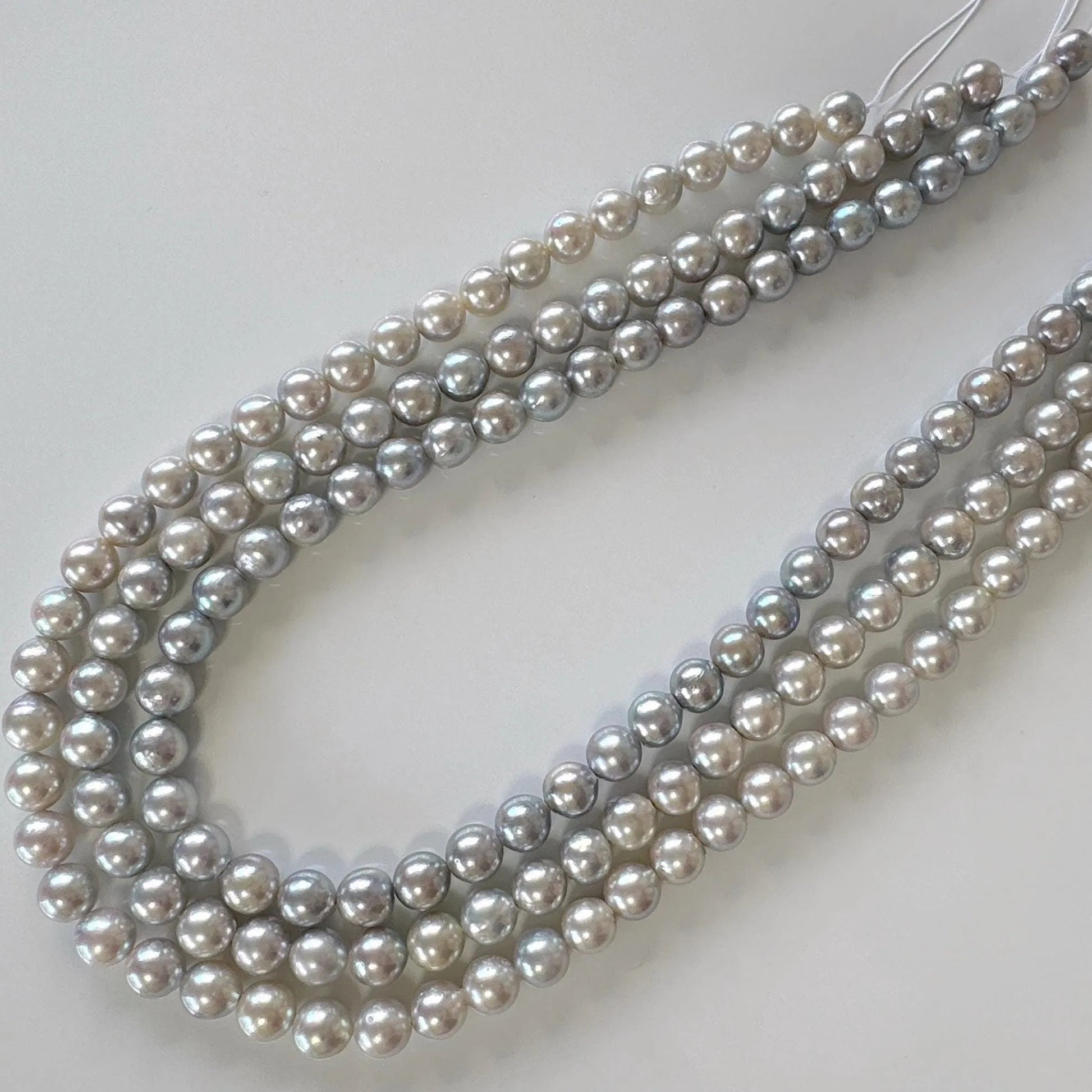 A necklace composed of multiple strands of grey and white pearls arranged in a curved pattern.