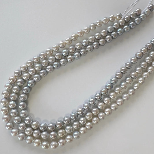 A necklace composed of multiple strands of grey and white pearls arranged in a curved pattern.