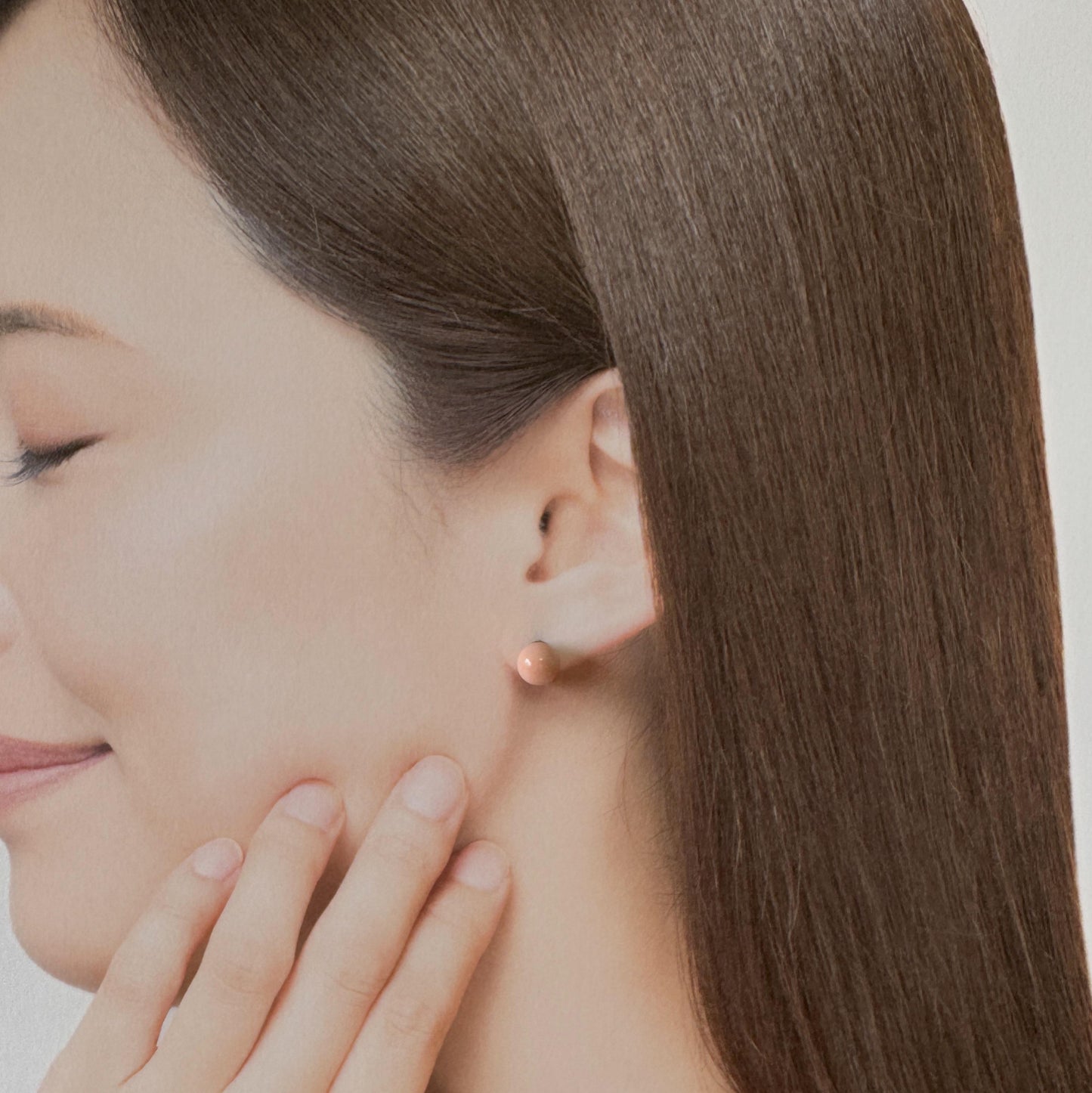 A close-up of a woman's face, focusing on her earrings and the side of her face.