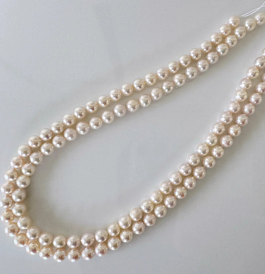 A necklace made of numerous white pearls arranged in a decorative pattern.