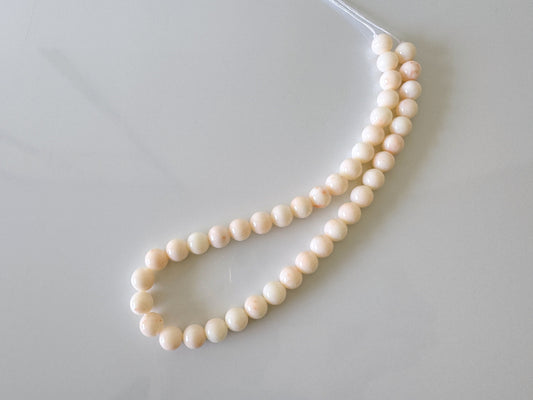 a white beaded necklace with a silver clasp