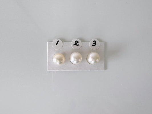 three pearls are placed on a white surface