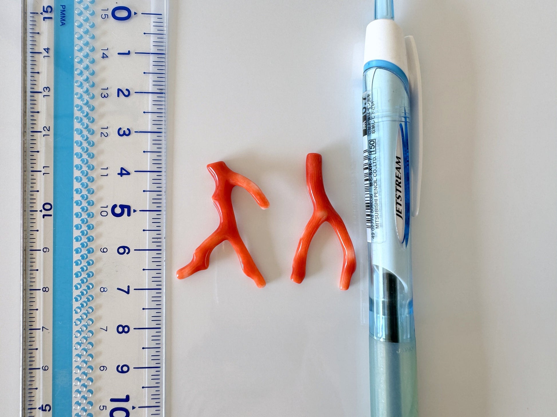 a pair of scissors, a ruler, and a pair of orange scissors