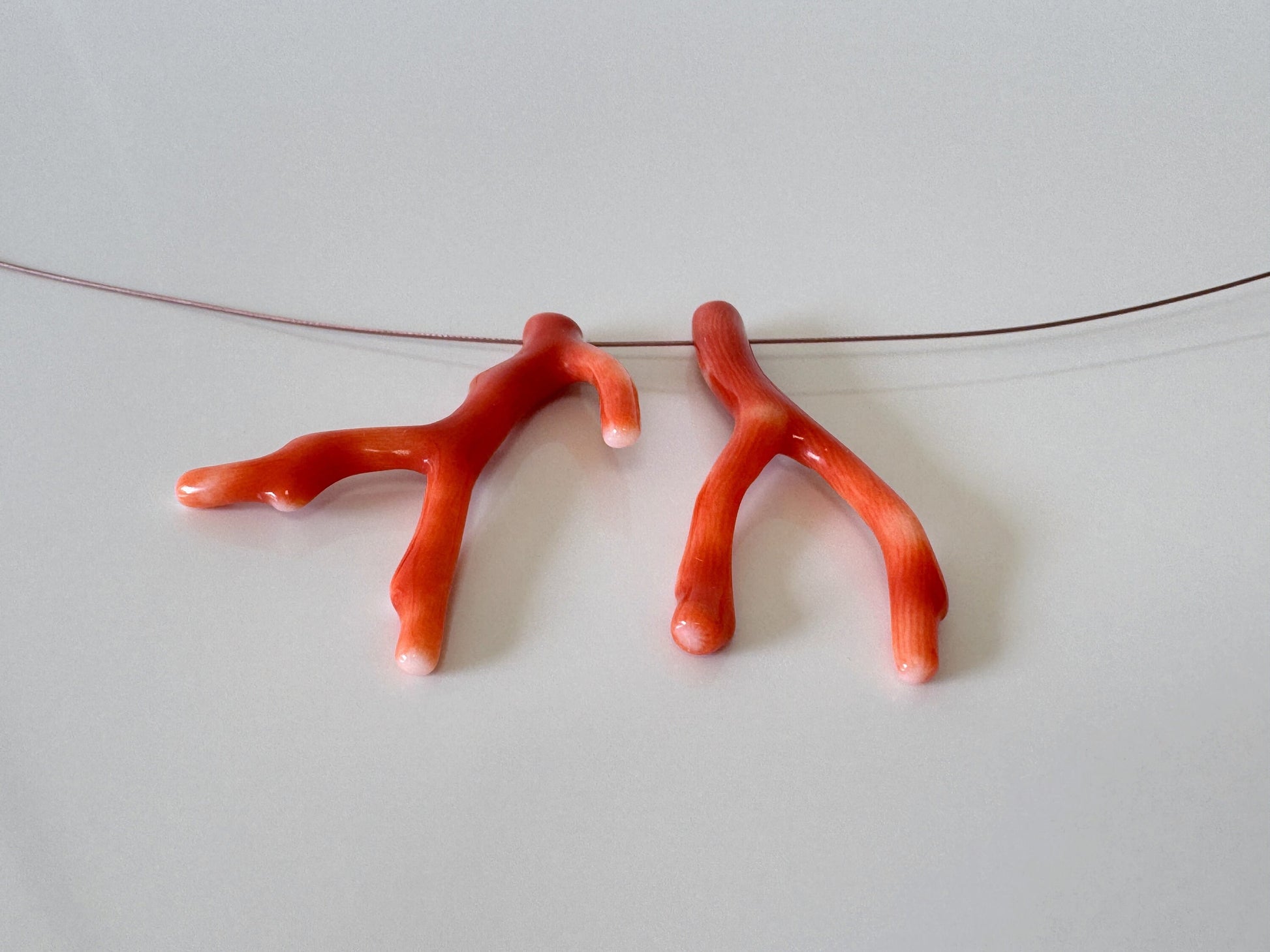 a pair of red plastic antlers hanging from a wire