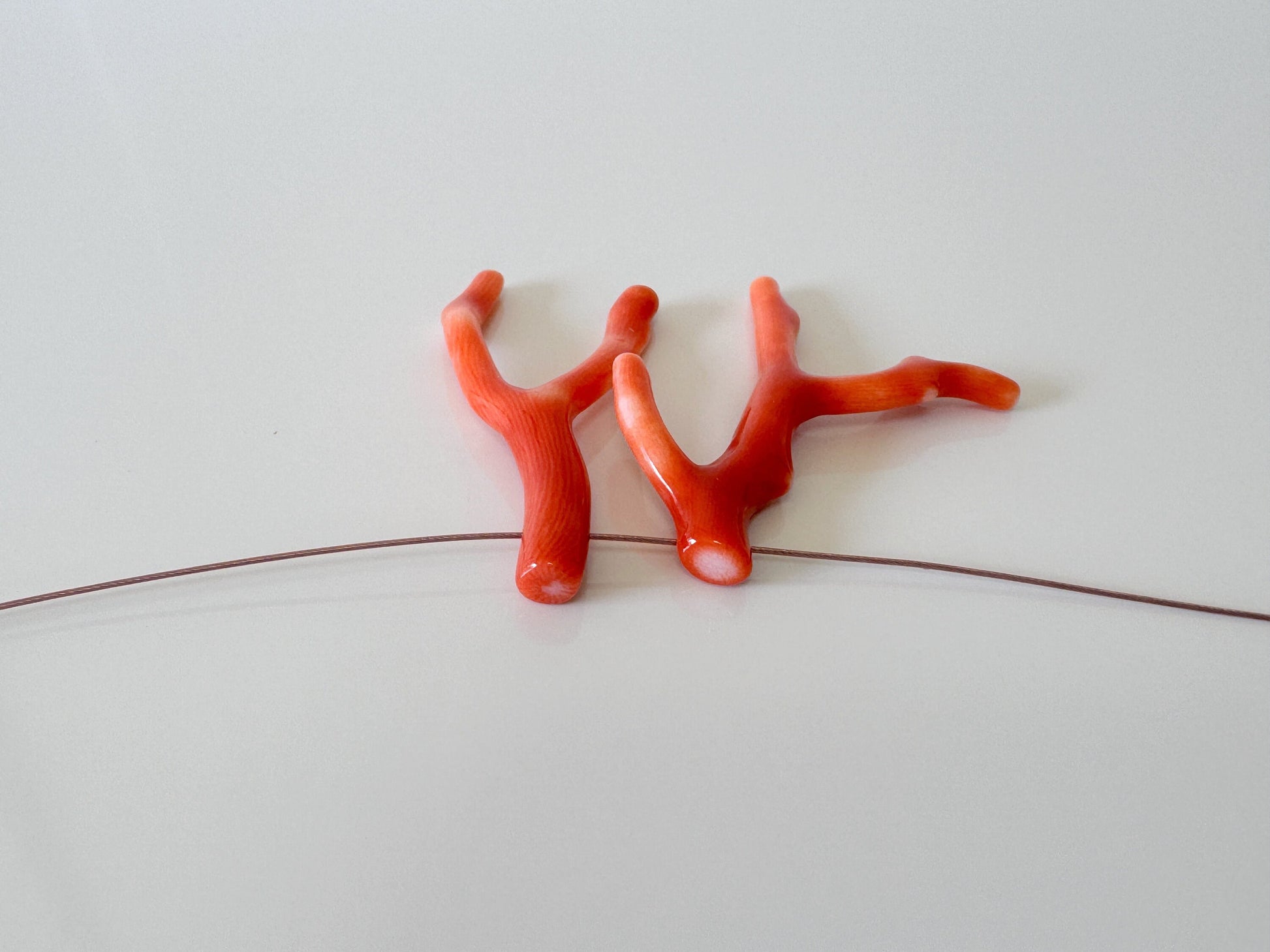 a couple of red plastic figures sitting on top of a white surface