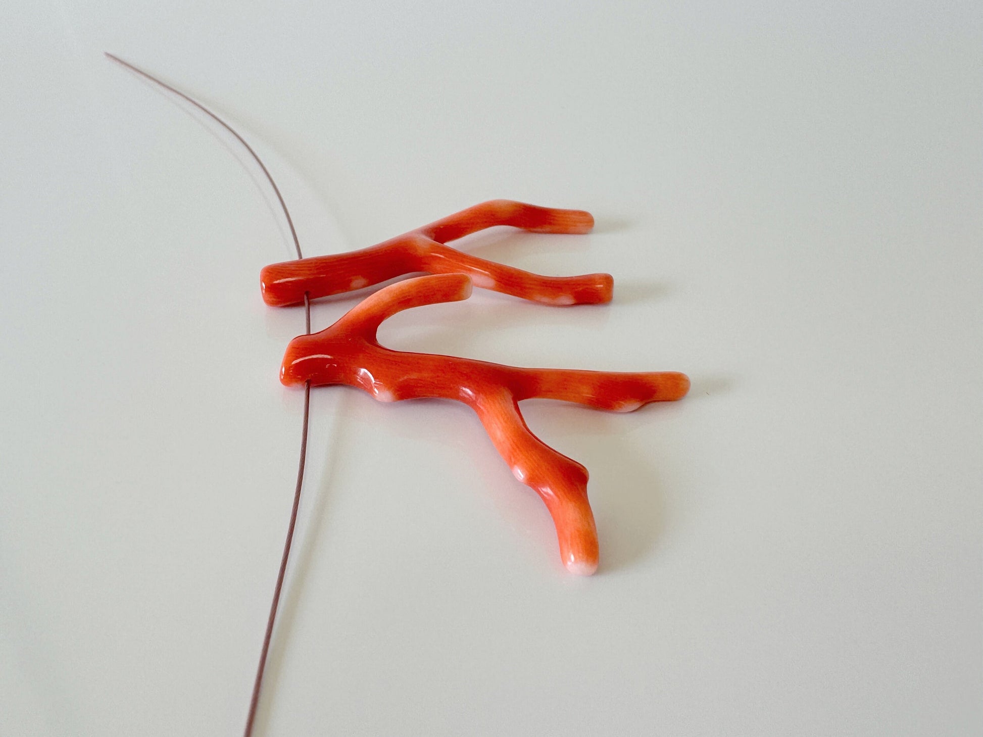 a pair of red scissors laying on top of a white table