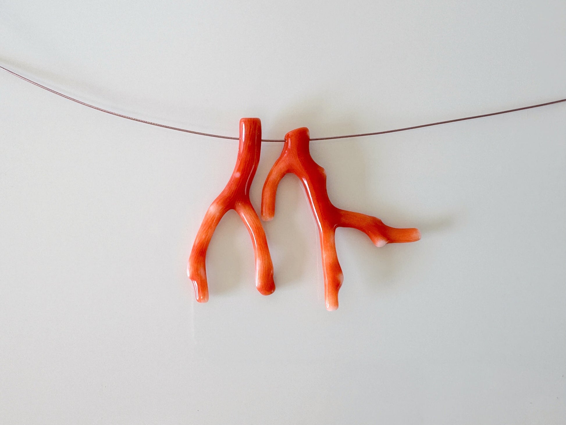 a pair of orange scissors hanging on a string