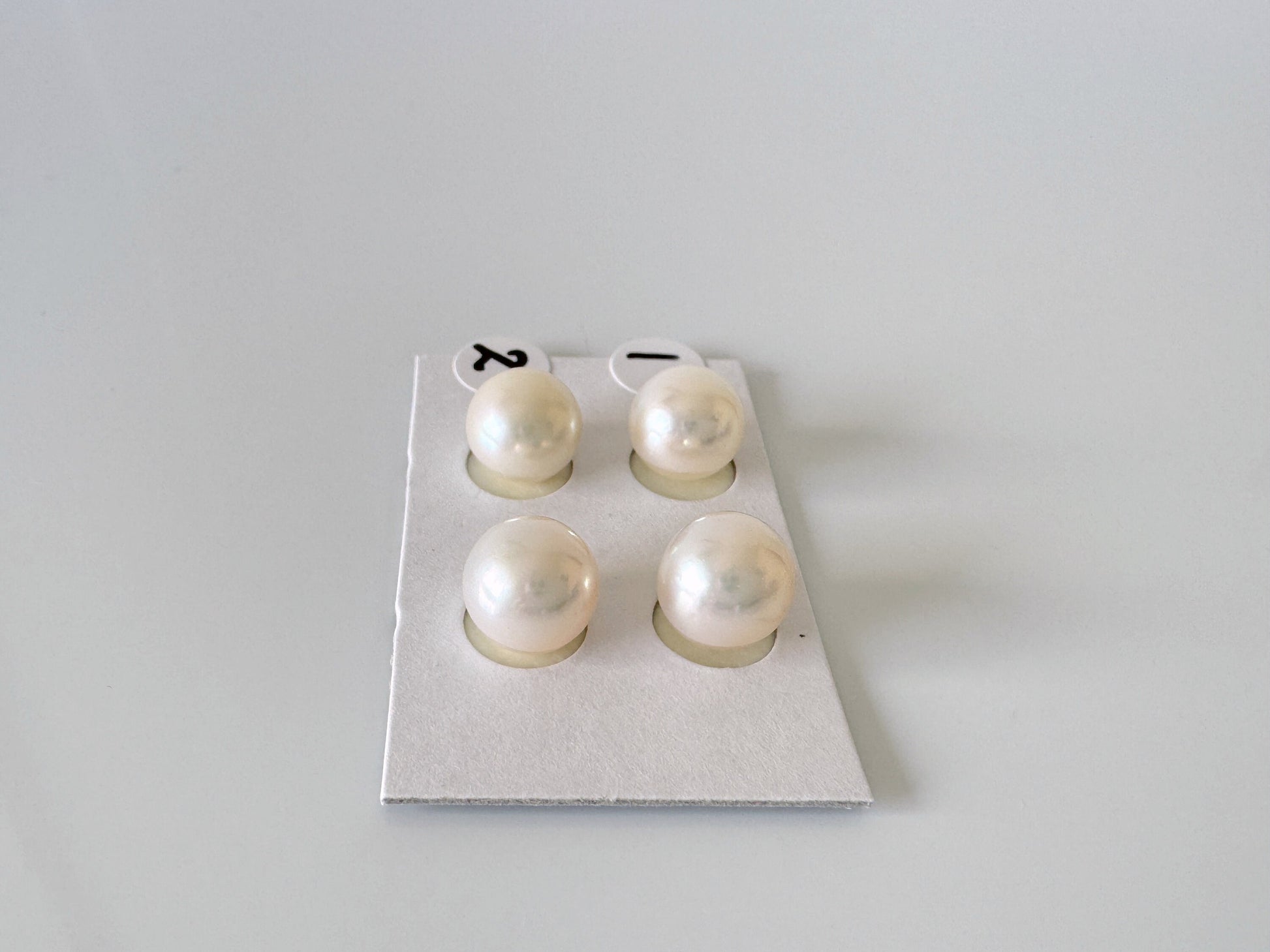 a pair of pearl earrings sitting on top of a piece of paper