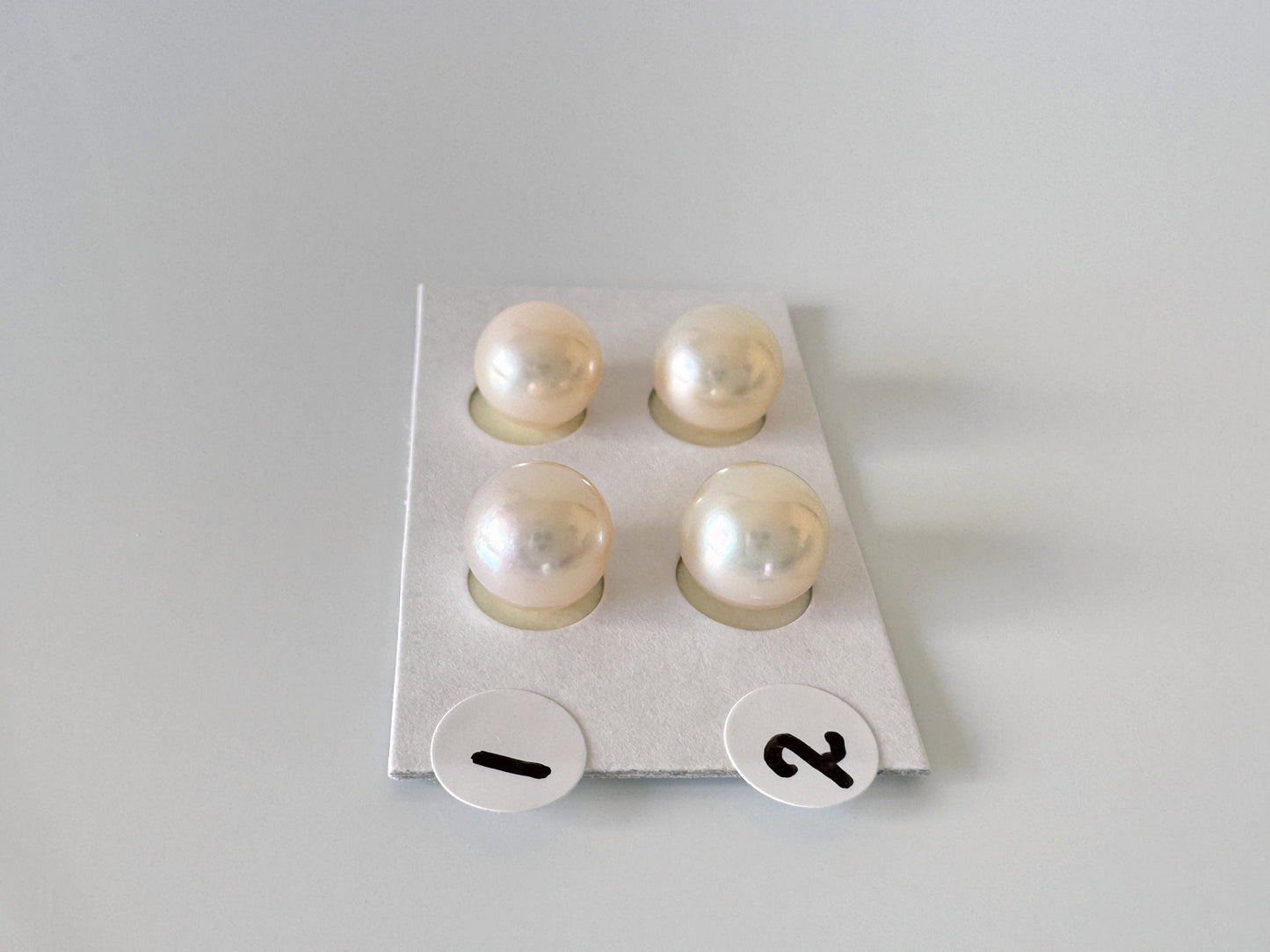 a set of four pearls sitting on top of a piece of paper