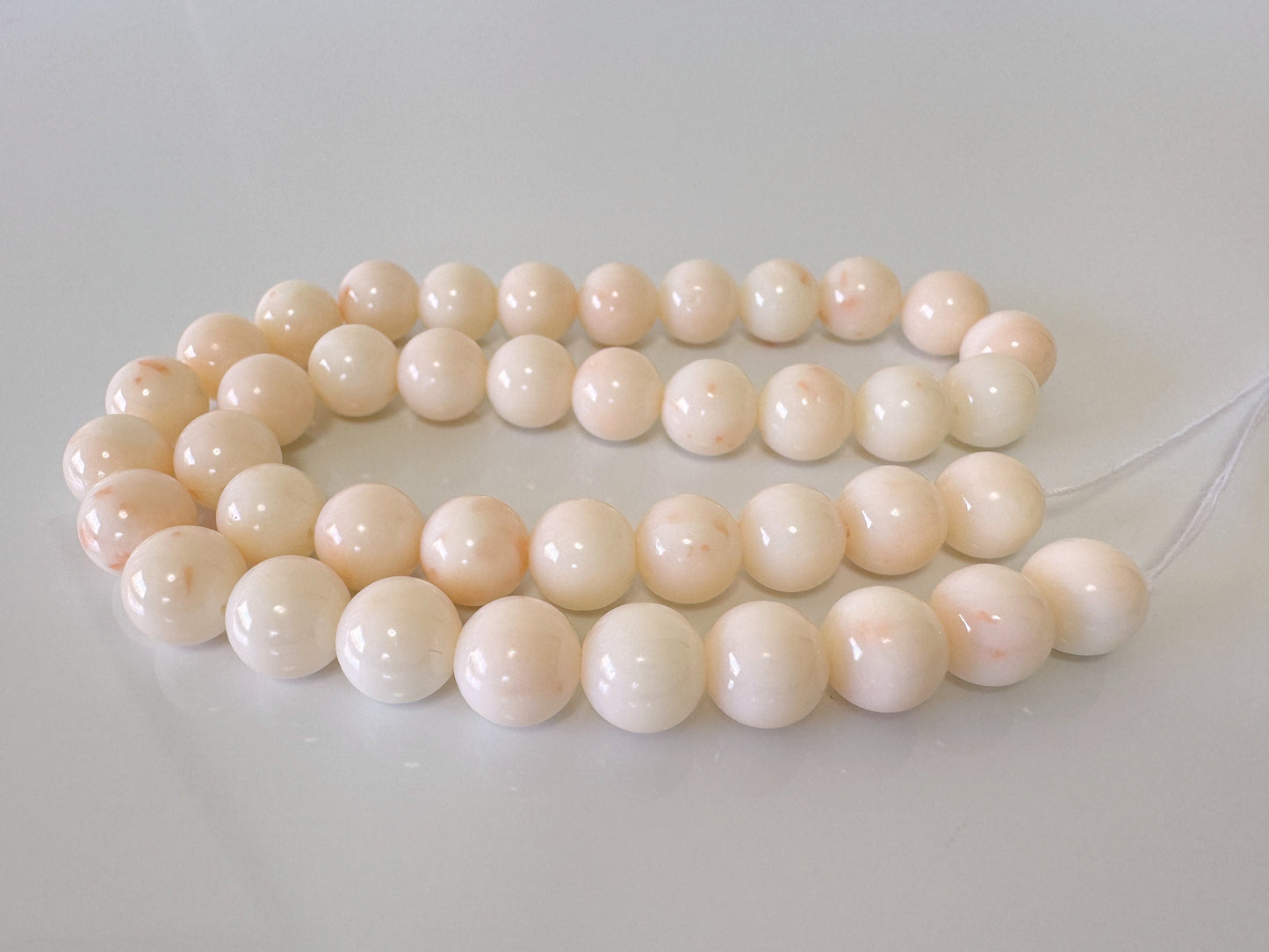 a string of white beads on a white surface