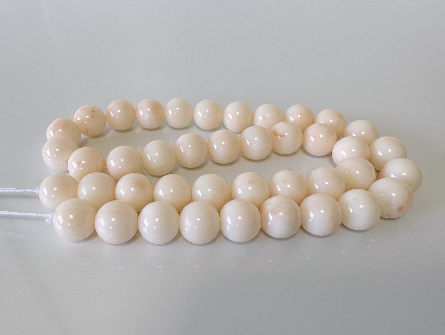 a bunch of white beads on a white surface