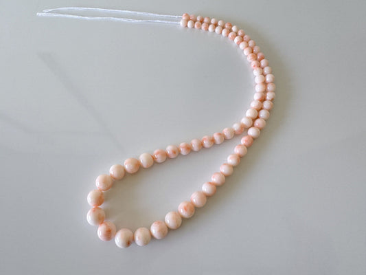 a single strand of pink and white beads