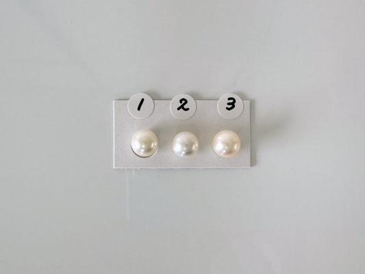 a pair of pearls sitting on top of a white board