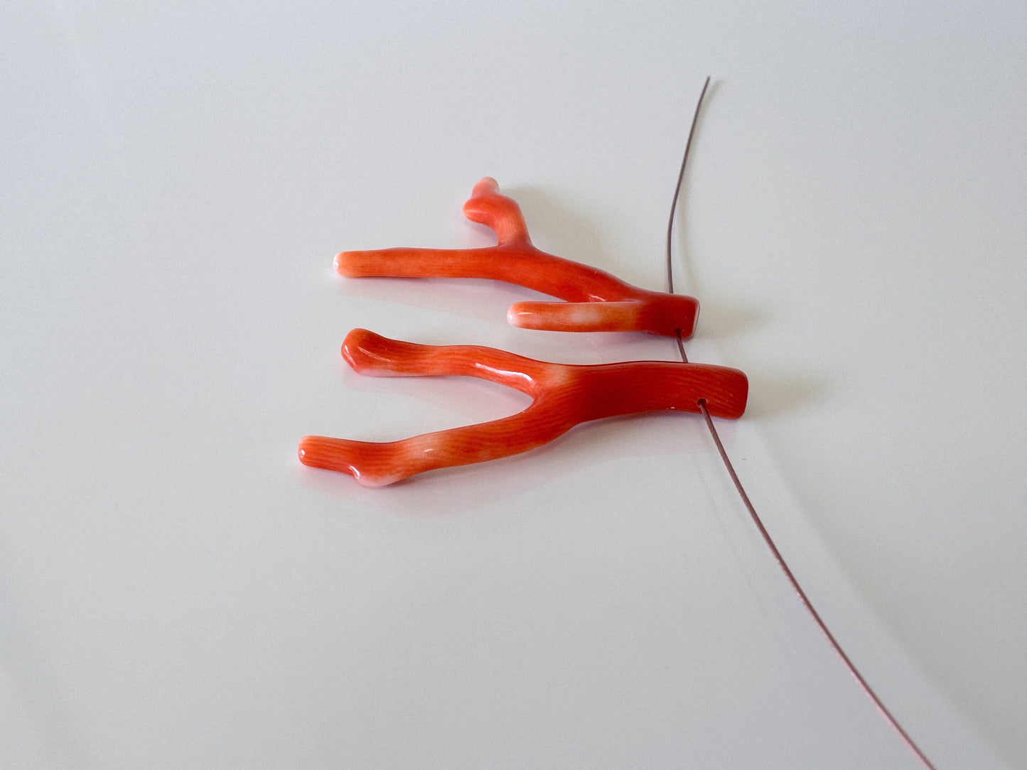 a pair of red scissors laying on top of a white surface