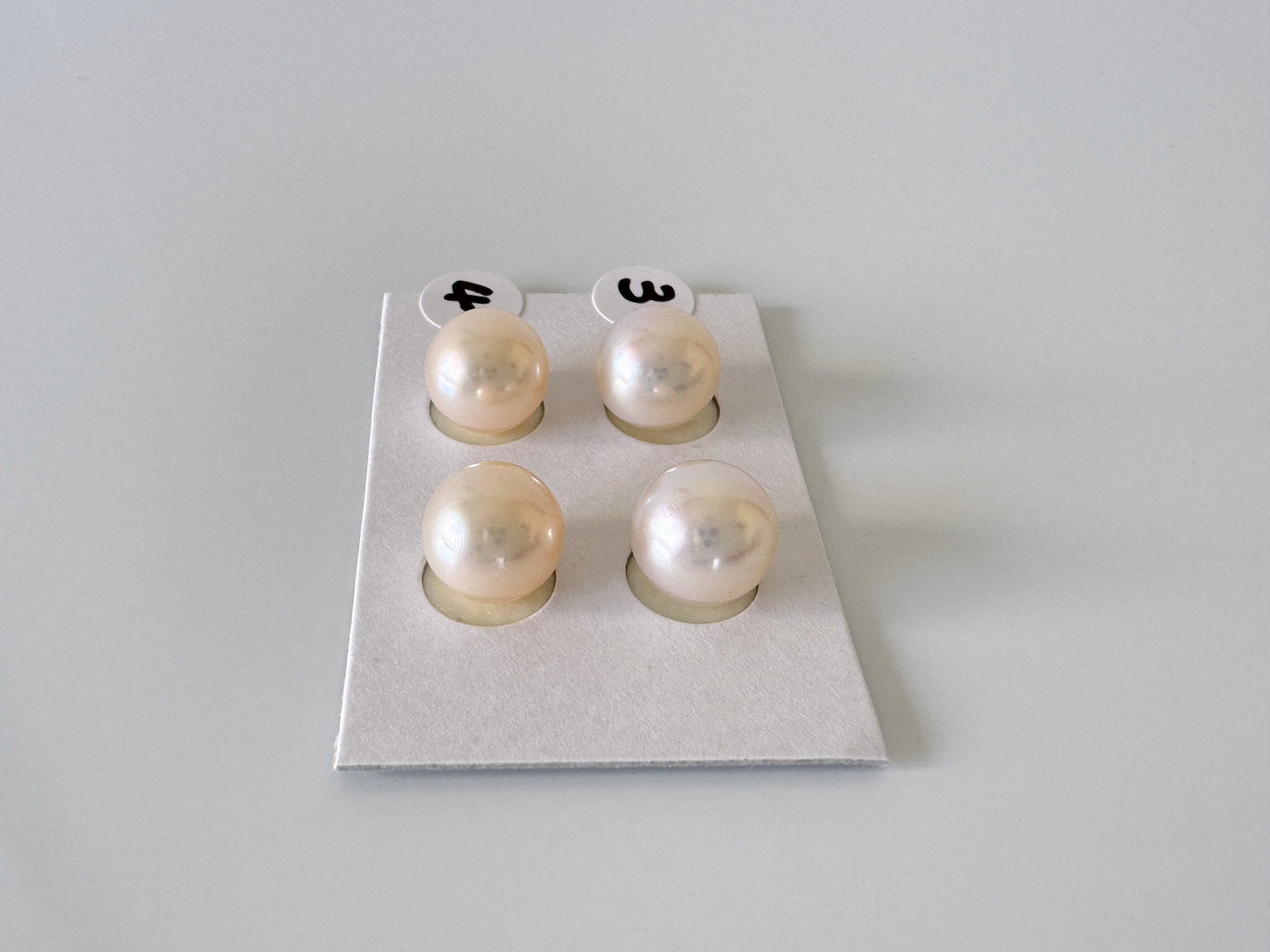 four pearls are placed on a white surface