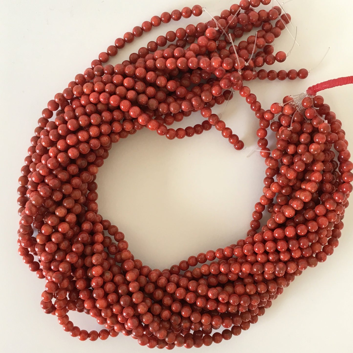 a string of red beads on a white surface