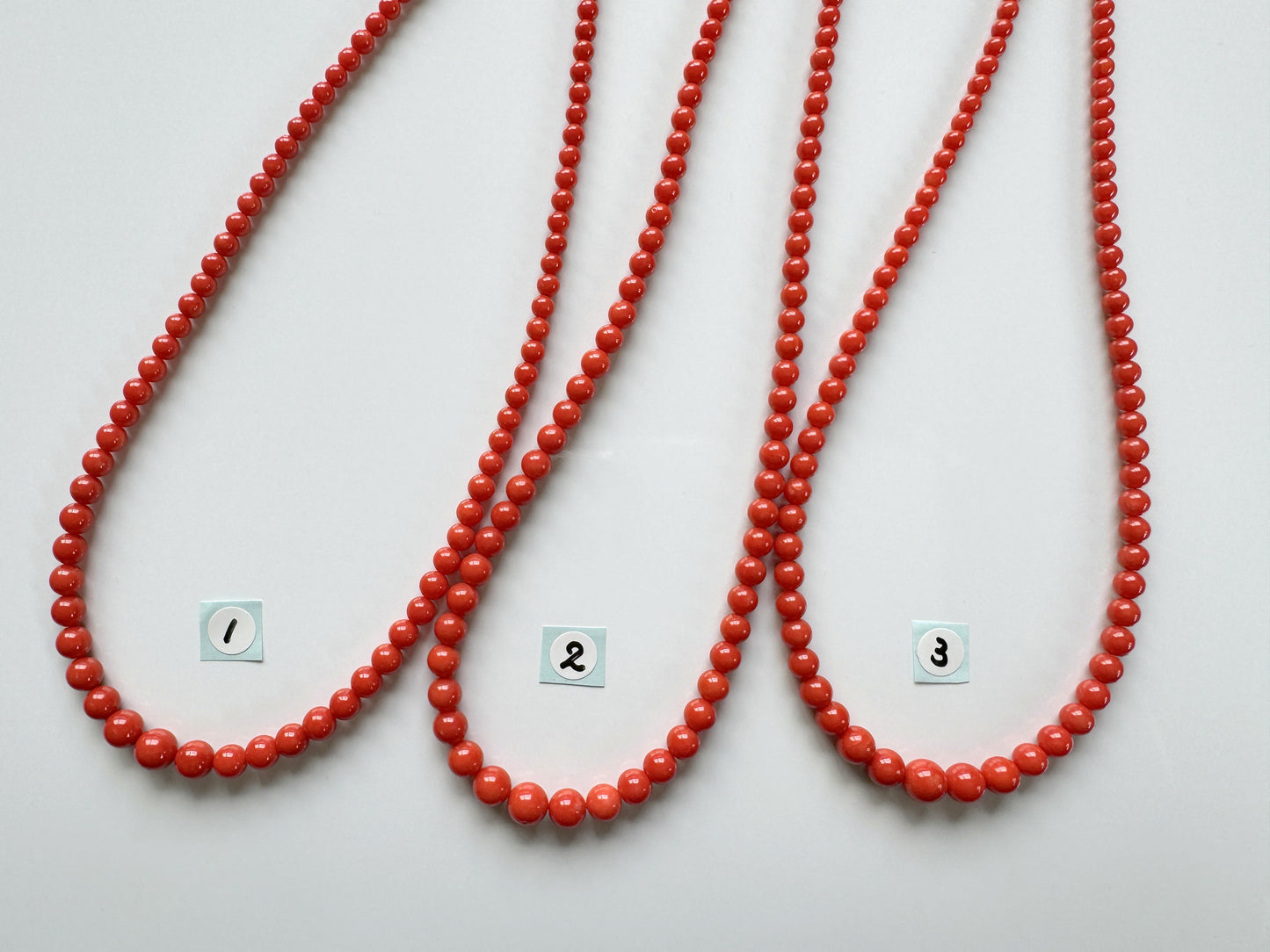 a group of three red beads on a white surface