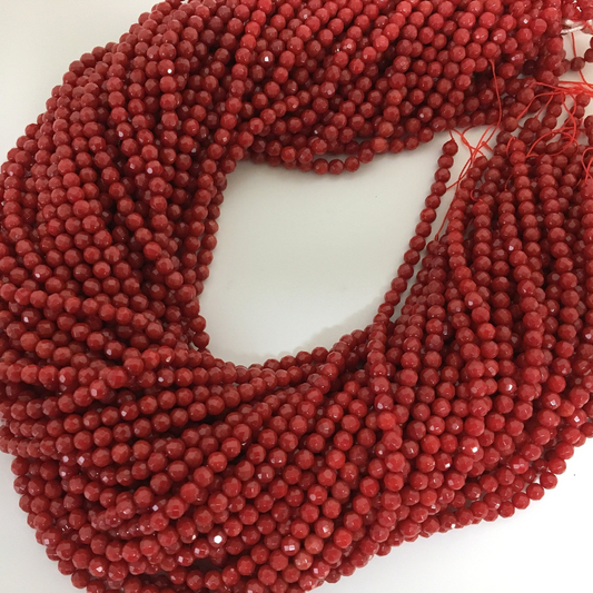 a bunch of red beads on a white surface