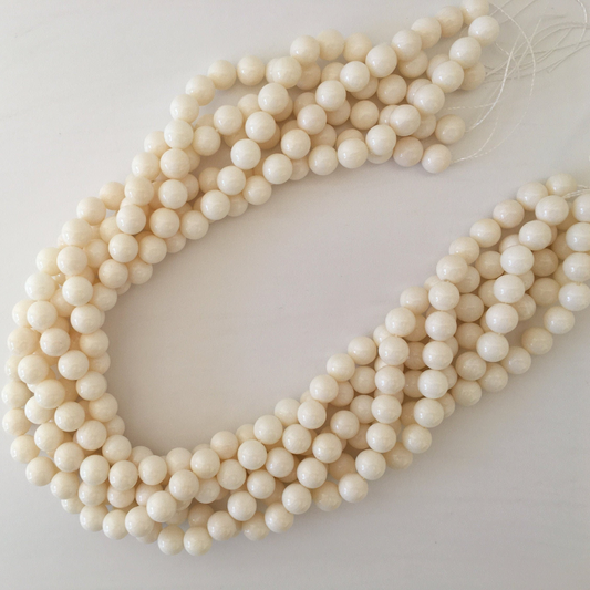 a strand of white beads on a white surface