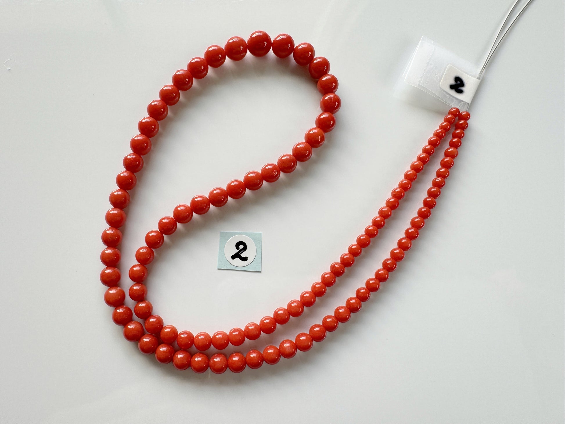 a red beaded necklace with a number on it