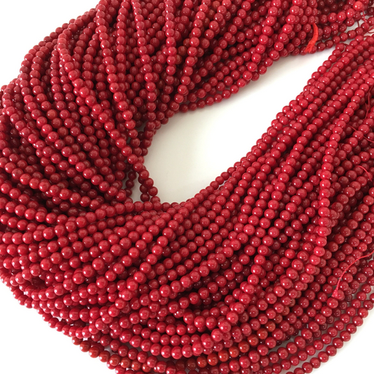a strand of red beads on a white surface