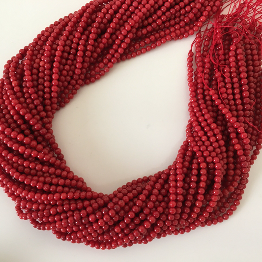 a strand of red beads on a white surface
